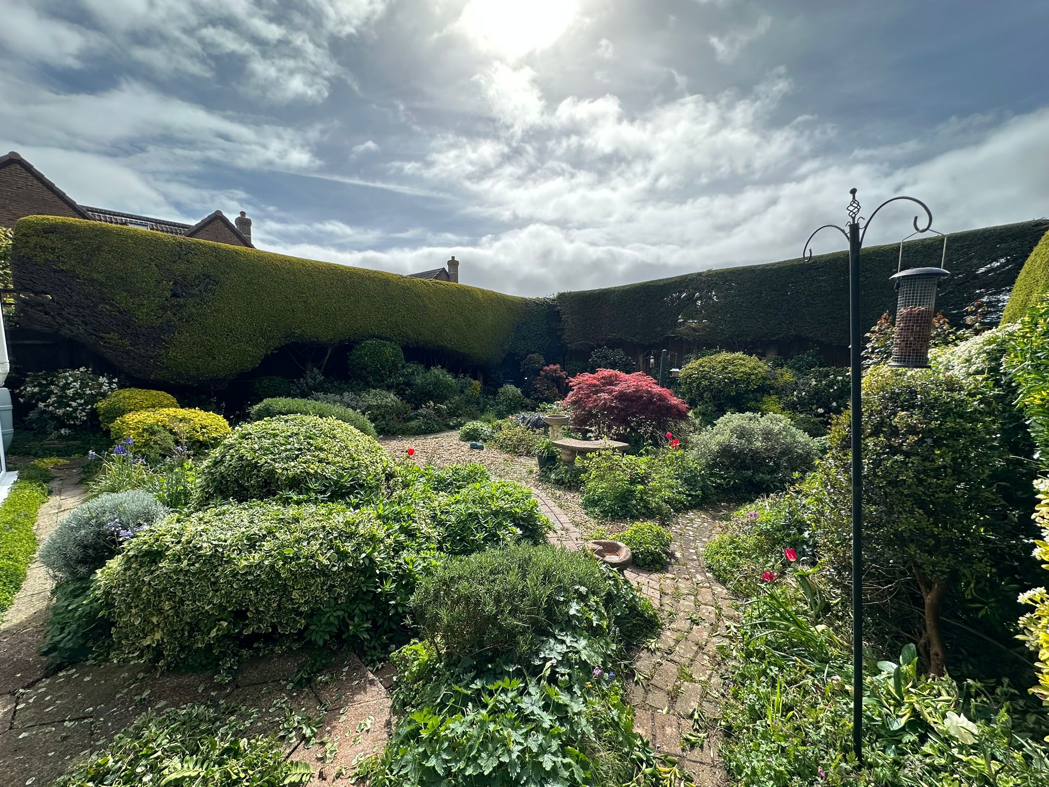 Formal garden with clipped hedges and stone path, maintained on Hayling Island