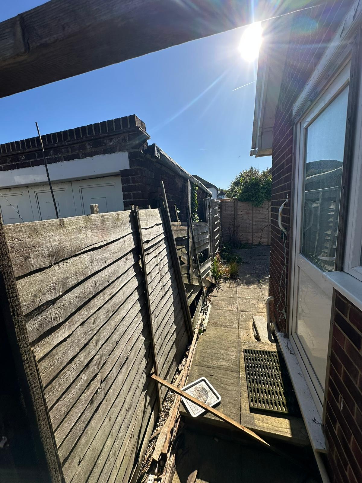 Collapsing storm-damaged fence before replacement on Hayling Island