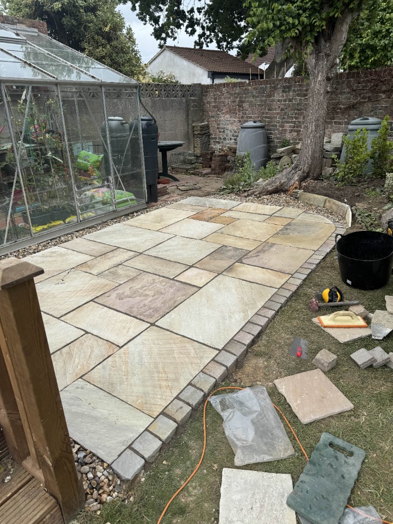 New Indian sandstone patio with a setts border laid by EHW Landscapes in Hampshire