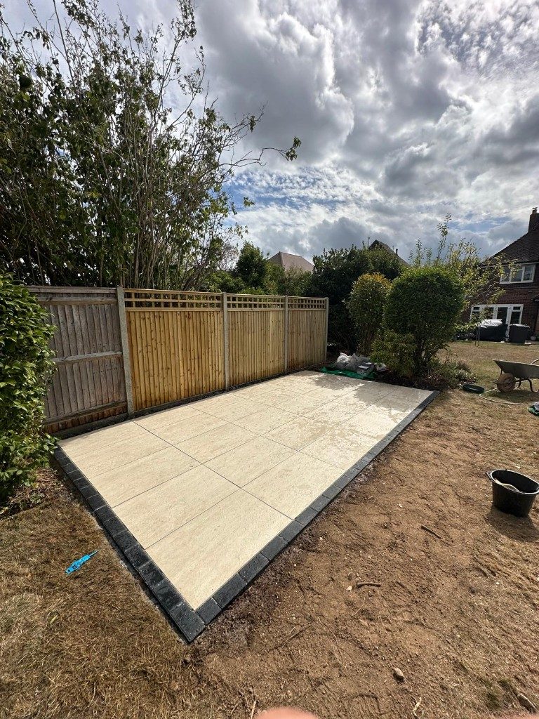 Cream patio slabs with a dark border laid in place of the old concrete path