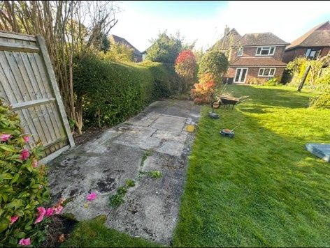 Old concrete slabs beside a lawn before a new patio was laid in Hampshire